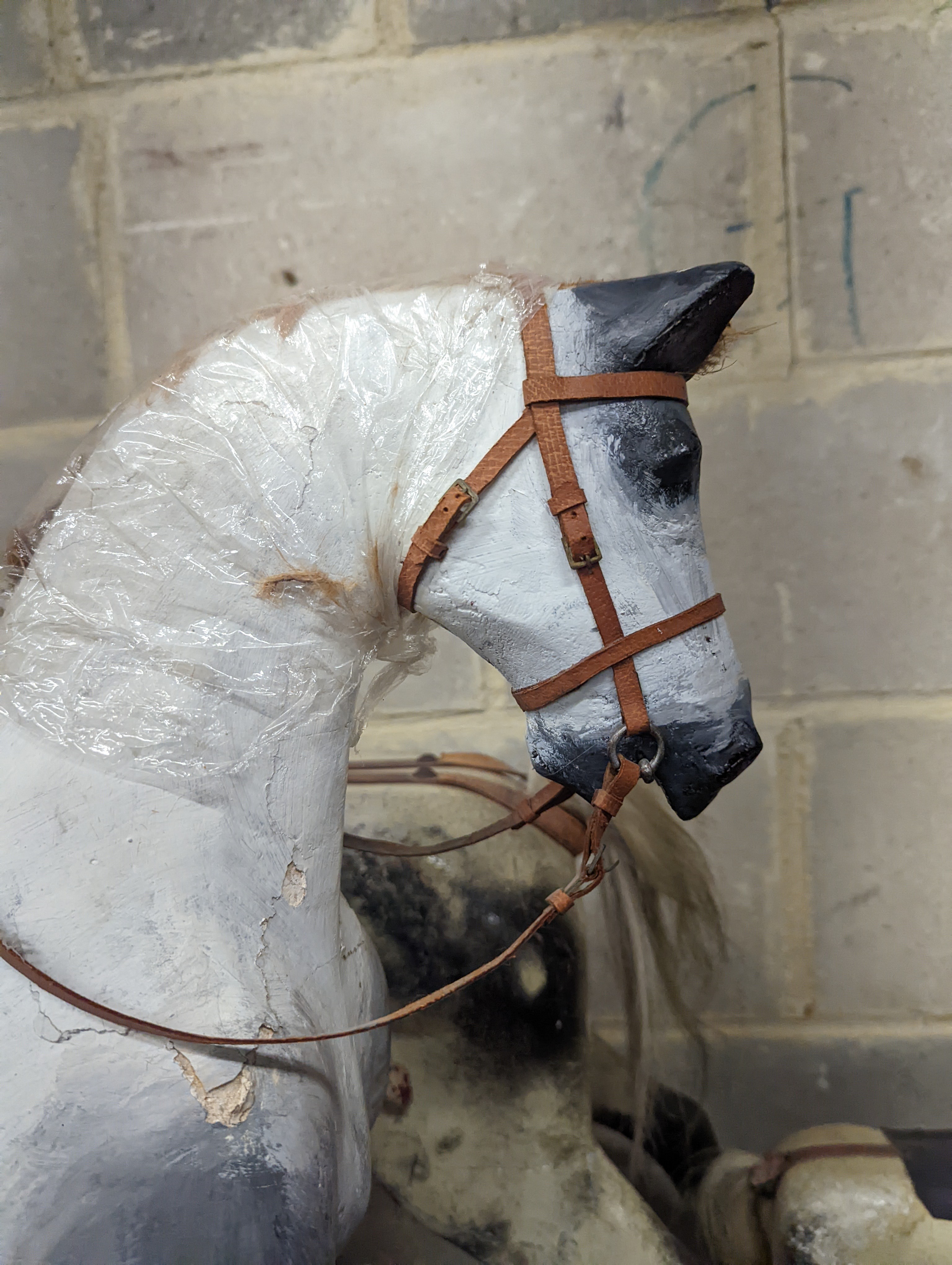 A Victorian carved and painted wood rocking horse, lacking underframe, length 77cm and two painted wood hobby horses, 58cm and 38cm